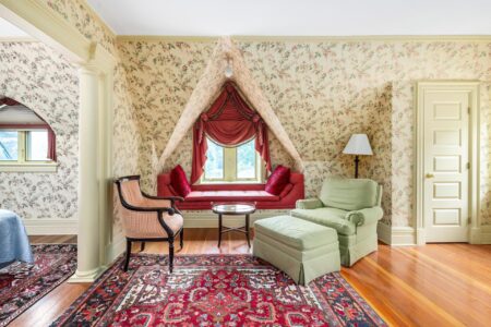 A Lake George hotel room featuring a window and a chair at Erlowest.