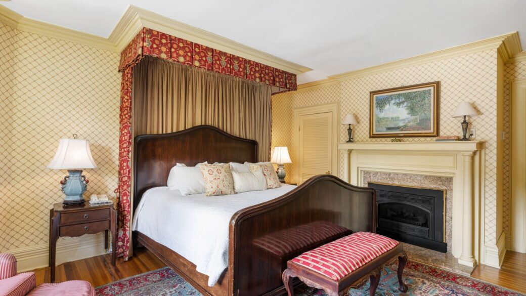 A Lake George suite with a large bed and a fireplace.