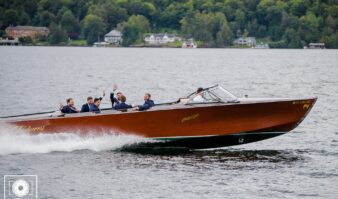 A group of people riding in a boat on the water near Lake George hotels.