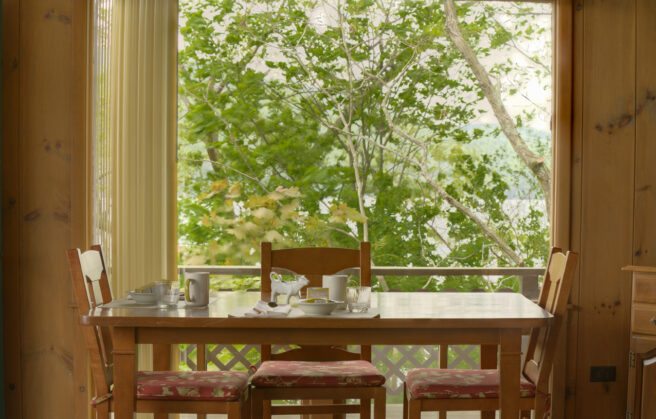 A wooden table and chairs at a lakefront resort in Lake George.