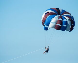 A person parasailing during their Lake George vacation.