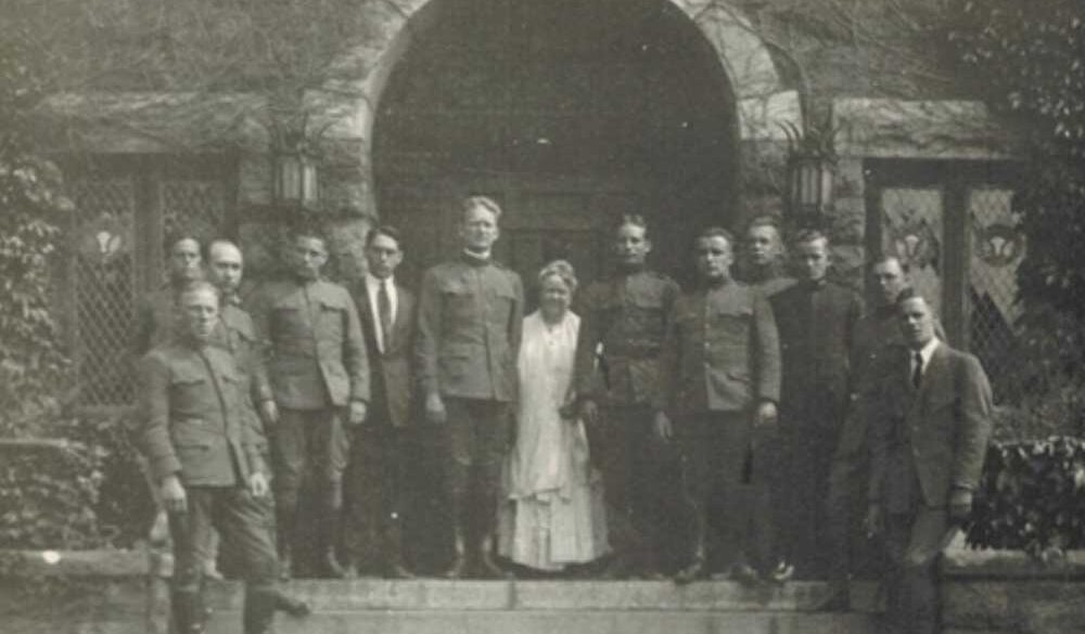 A group of people in military uniforms posing in front of a building.