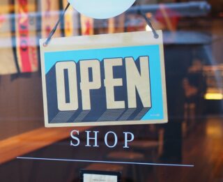 An open shop sign in the window of a shop close to The Erlowest