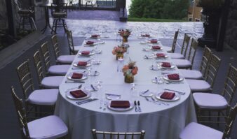 A table set up on a deck overlooking a lake.