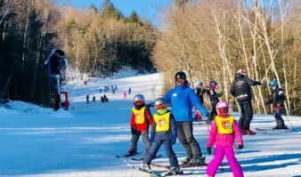 A group of children on skis on a snowy slope.