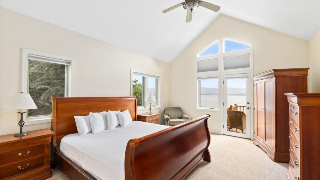 A bedroom with a bed, dresser, and a ceiling fan.