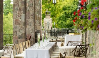 A stone patio with tables and chairs set up for a wedding.