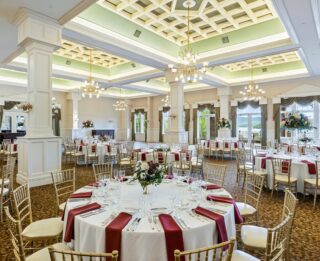 A large ballroom with tables and chairs set up for a wedding.