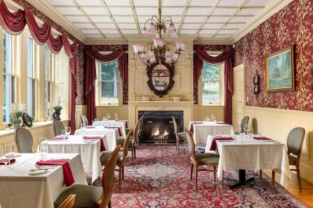 Experience the grandeur of an Erlowest dining room, adorned with ornate walls and featuring a charming fireplace.