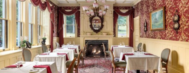 Experience the grandeur of an Erlowest dining room, adorned with ornate walls and featuring a charming fireplace.