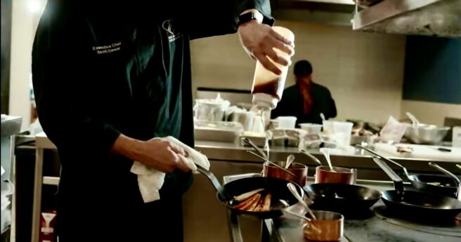 Restaurant Chef drizzling maple syrup on caramelized carrots