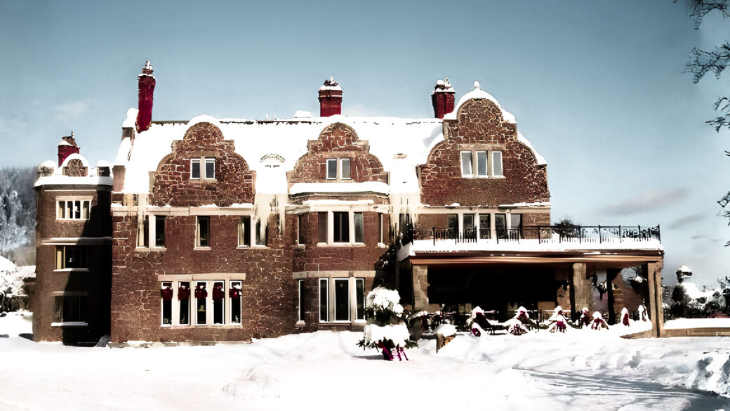 Snow-covered Erlowest castle in Lake George surrounded by winter trees and landscape