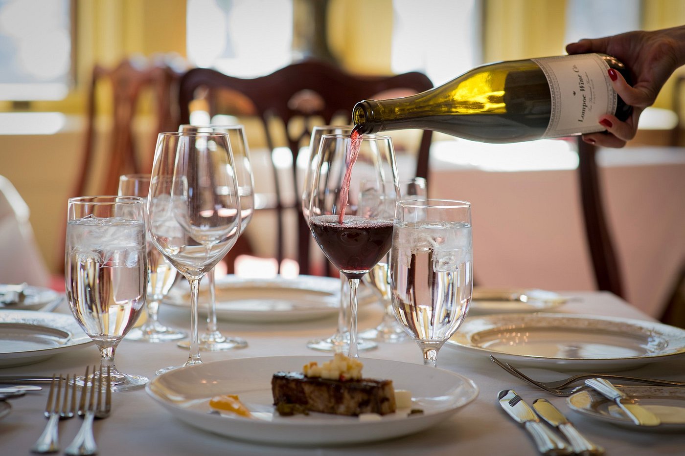 Sommelier pouring wine at tasting in a high-end restaurant.